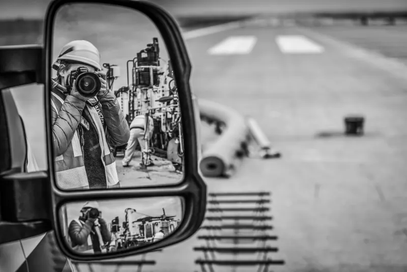 Fotografka v zrcátku auta při reportáži